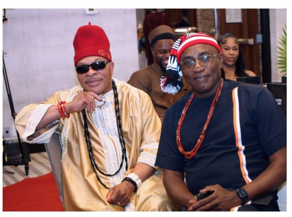 Two Igbo men seated together in traditional attire at a community gathering