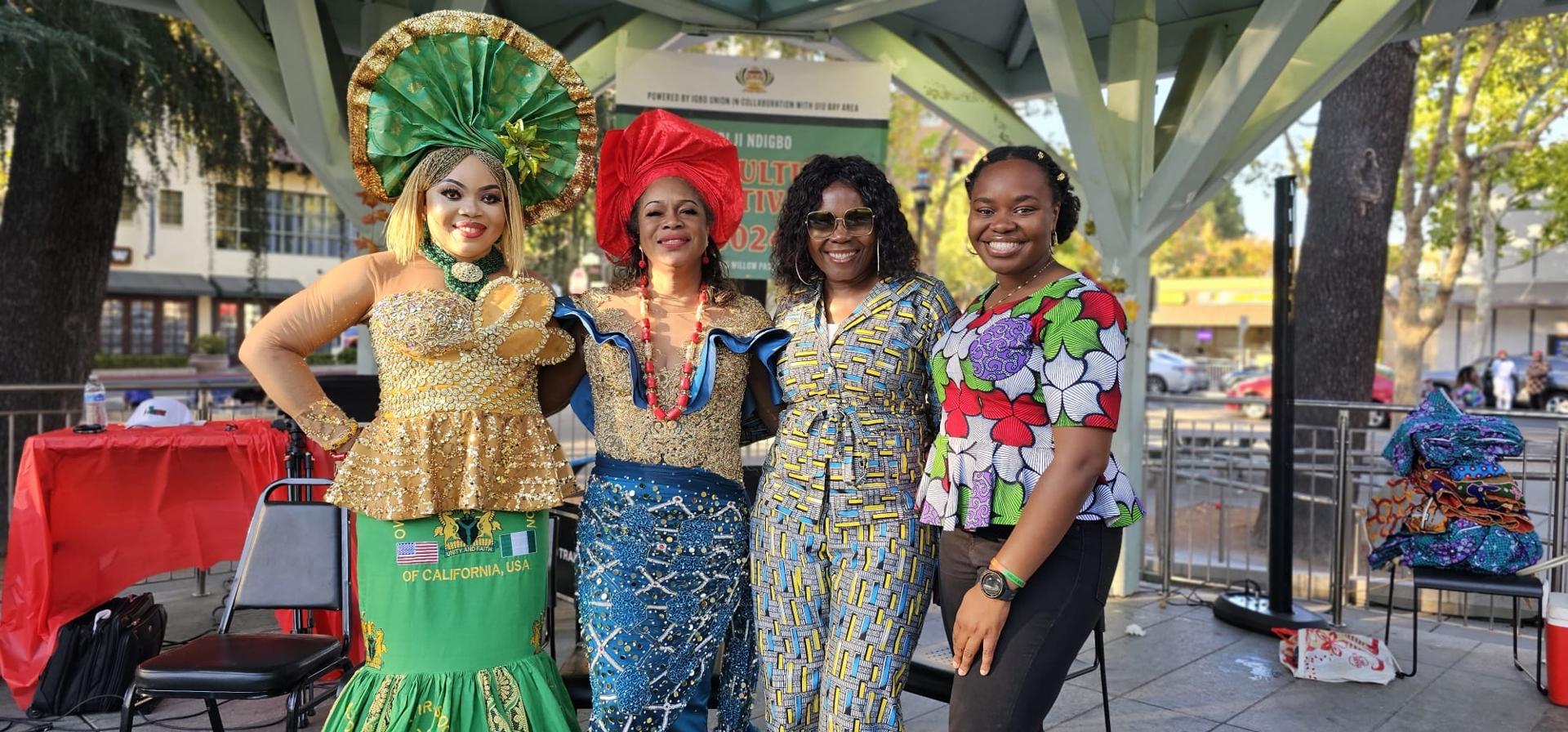 Four women smiling together in vibrant traditional attire