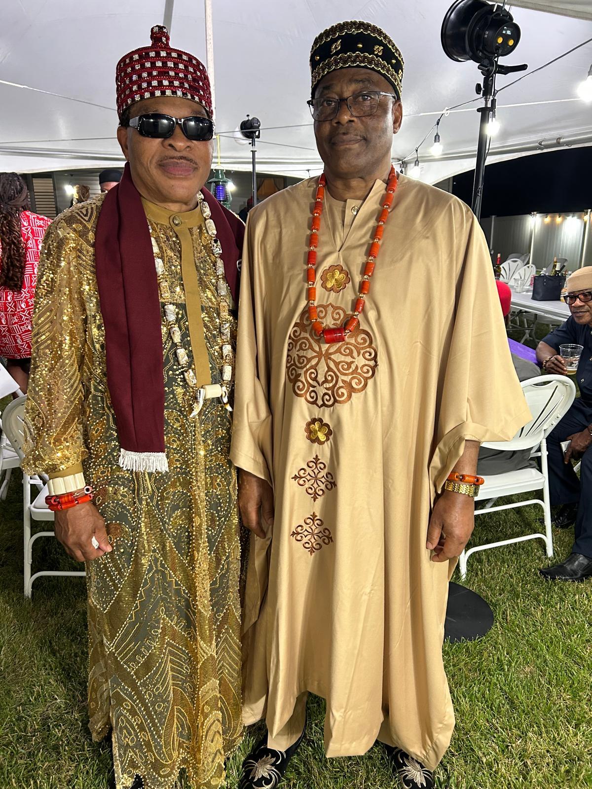 Two community members wearing ceremonial attire and coral beads