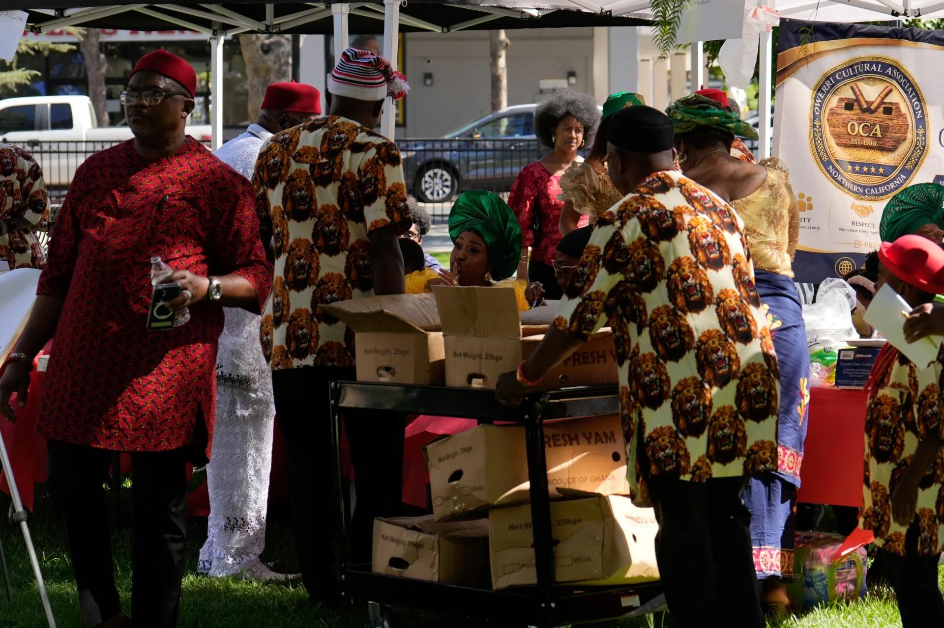 Community members in matching lion-print attire unloading fresh yam at the festival