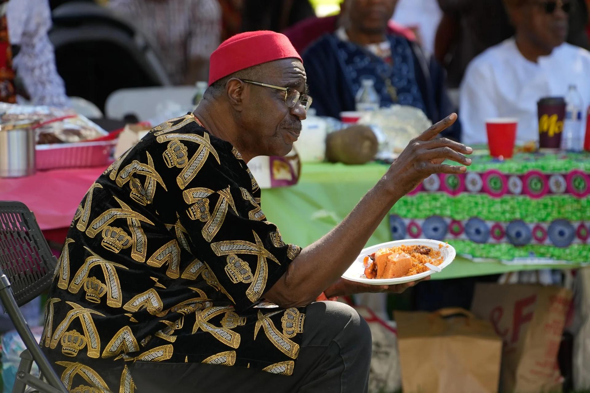 Community elder holding a plate of jollof rice at the festival